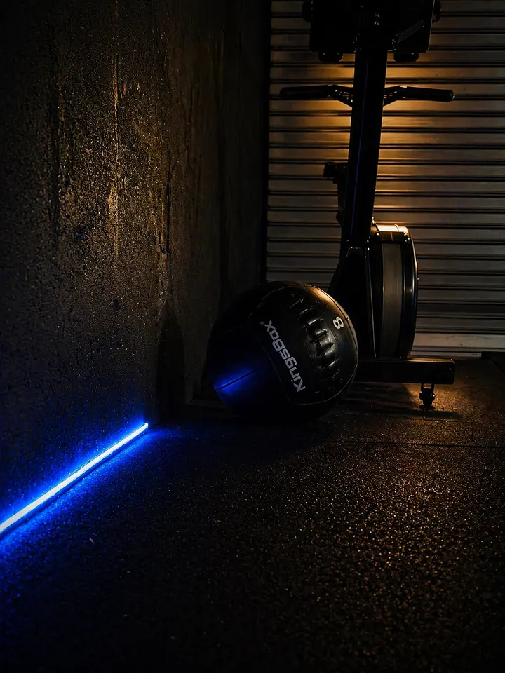 An exercise bike positioned next to a concrete wall in a darkened studio setting