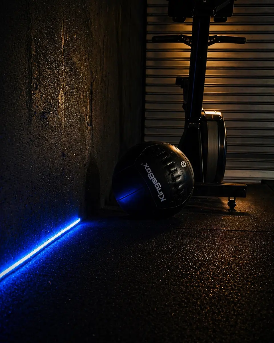 An exercise bike positioned next to a concrete wall in a darkened studio setting
